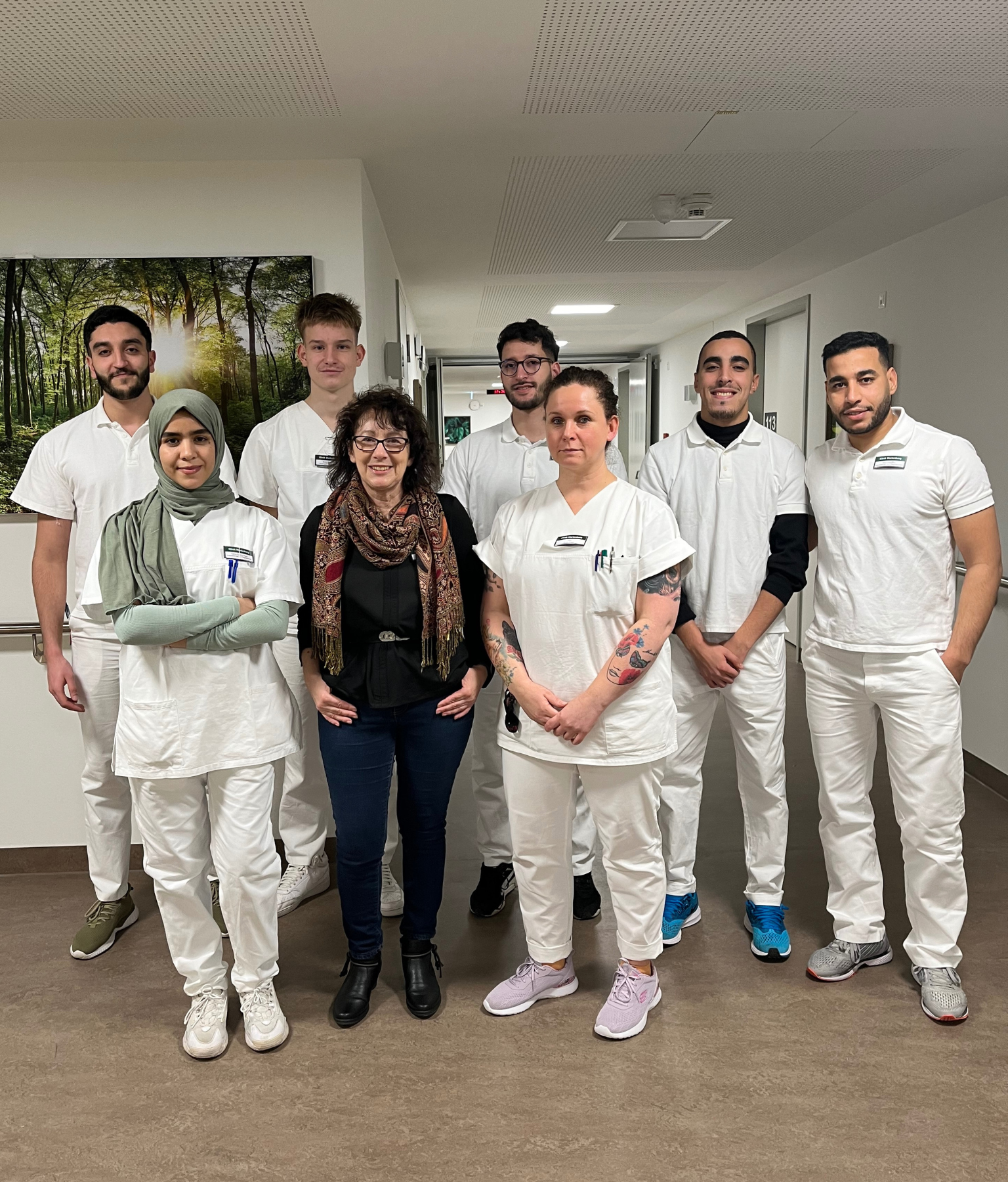 Gruppenfoto der Auszubildenden in den Pflegeberufen zusammen mit der zentralen Praxisanleiterin.